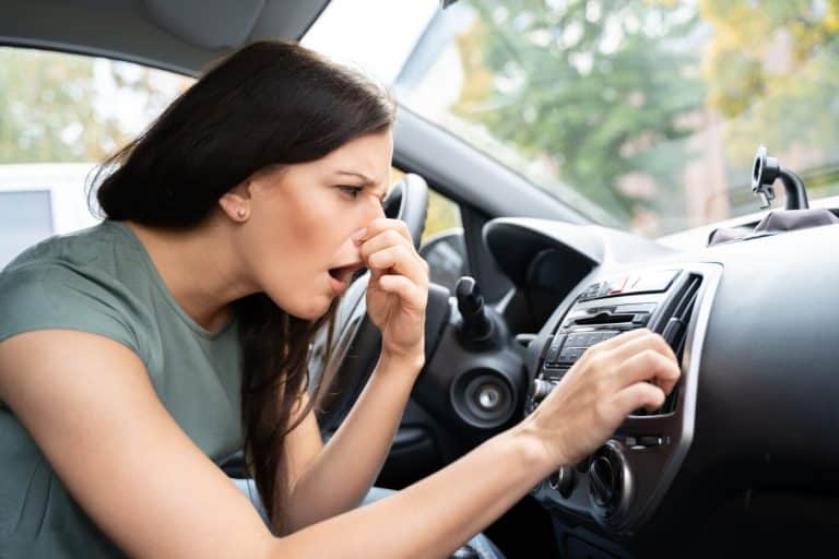 a woman holding her nose in a car